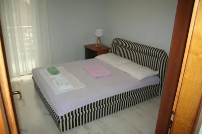 a small bed in a room with a window at Beachfront apartment in Becici,Rafilovici,Budva in Budva