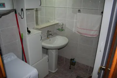 a small bathroom with a sink and a toilet at Beachfront apartment in Becici,Rafilovici,Budva in Budva