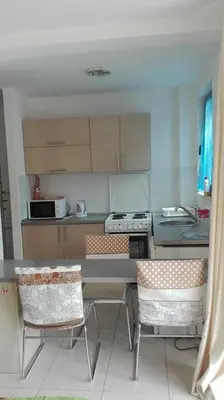 a kitchen with a table and two chairs in it at Bečići Sunset Apartments in Becici