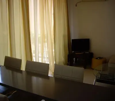a living room with chairs and a table and a television at Bečići Sunset Apartments in Becici