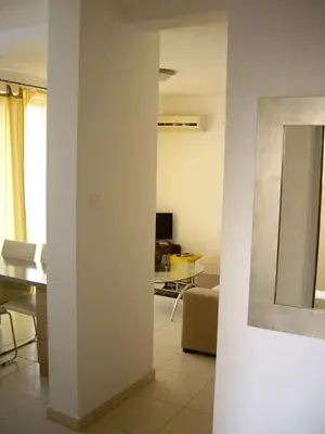a living room with a table and a mirror at Bečići Sunset Apartments in Becici