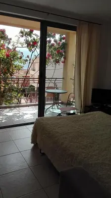 a bedroom with a bed and a view of a balcony at Bečići Sunset Apartments in Becici
