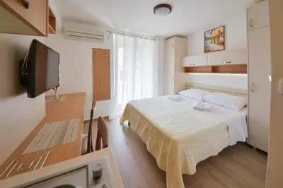 a small bedroom with a bed and a television at Apartmani Ljubo Rafailovic 2 in Rafailovici