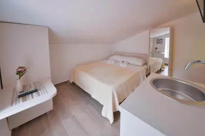 a small room with a bed and a sink at Apartmani Ljubo Rafailovic 2 in Rafailovici