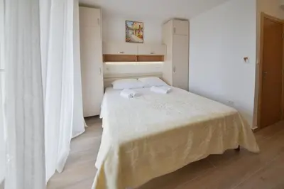 a bedroom with a bed with two towels on it at Apartmani Ljubo Rafailovic 2 in Rafailovici