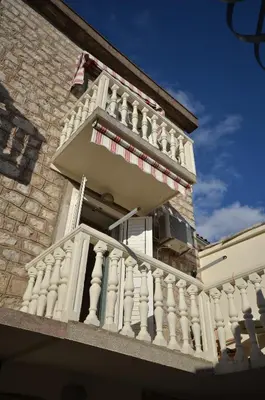 a white building with a balcony on the side of it at Apartmani Ljubo Rafailovic 2 in Rafailovici