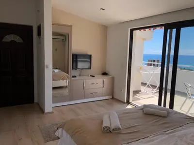 a bedroom with a bed and a view of the ocean at Days Inn Apartments in Ulcinj