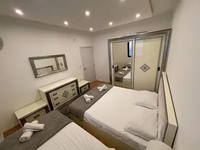 a small bedroom with two beds and a mirror at Days Inn Apartments in Ulcinj