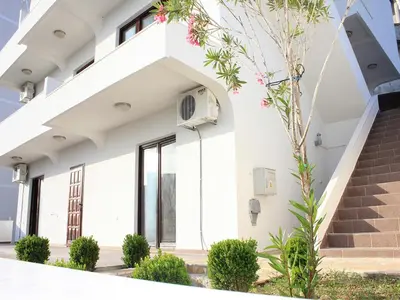 a white house with stairs and plants at Days Inn Apartments in Ulcinj
