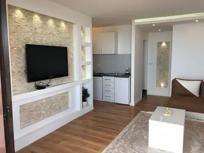 a living room with a flat screen tv on a wall at Days Inn Apartments in Ulcinj
