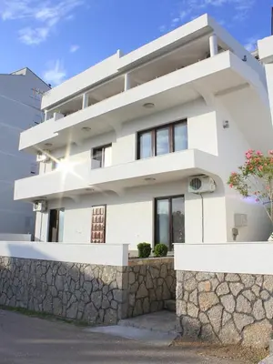 a white house on a stone wall at Days Inn Apartments in Ulcinj