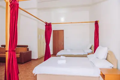 a room with two beds and red curtains at Apartmani Lasta in Dobra Voda