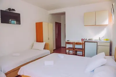 a small room with two beds and a kitchen at Apartmani Lasta in Dobra Voda