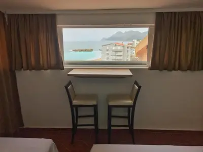 a table and two chairs in a room with a window at Apartmani Lasta in Dobra Voda