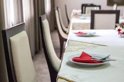 a table with a plate with a red napkin on it at Hotel Terminus in Podgorica