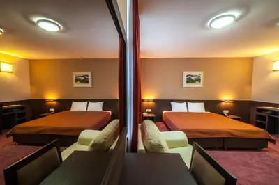 a hotel room with two beds and a table and chairs at Hotel Terminus in Podgorica