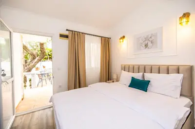 a bedroom with a white bed and a balcony at Apartments Irena in Becici