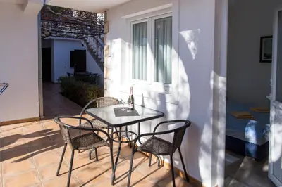 a table and chairs on a patio with a bed at Apartments Irena in Becici