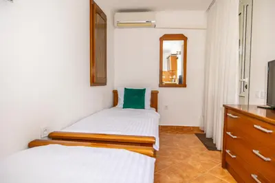 a bedroom with two beds and a mirror and a dresser at Apartments Irena in Becici