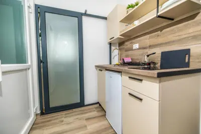 a kitchen with white cabinets and a glass door at Apartments Irena in Becici