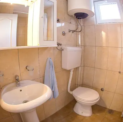 a bathroom with a toilet and a sink at Fisherman House Apartments in Rafailovici