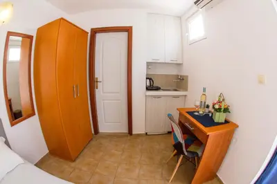 a small room with a desk and a kitchen at Fisherman House Apartments in Rafailovici