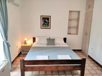 a bedroom with a large bed in a room at Fisherman House Apartments in Rafailovici
