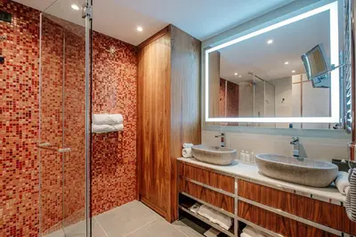 a bathroom with two sinks and a glass shower at ĀNANTI Resort, Residences & Beach Club - The Leading Hotels of the World in Sveti Stefan