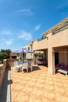 a patio with chairs and an umbrella on a building at Apartments Mila Krimovica in Krimovice