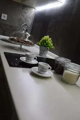 a kitchen counter with two coffee cups and a plant at Apartman Bloom in Bar