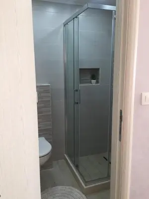 a glass shower in a bathroom with a toilet at Apartman Bloom in Bar