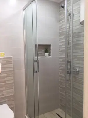 a shower with a glass door in a bathroom at Apartman Bloom in Bar