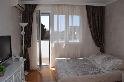 a bedroom with a bed and a sliding glass door at Apartman Bloom in Bar