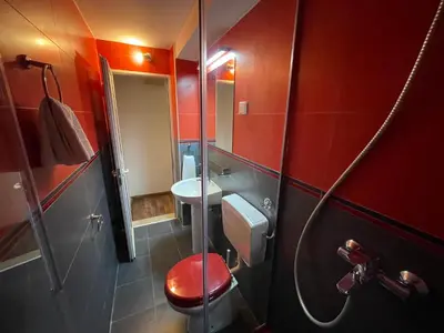 a red bathroom with a toilet and a sink at Guest house Villa Slavica in Sveti Stefan