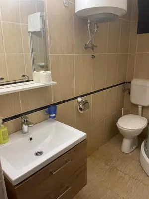 a bathroom with a sink and a toilet and a mirror at Guest house Villa Slavica in Sveti Stefan