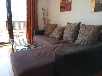 a living room with a couch and a glass table at Faith Apartman in Budva