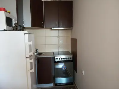 a small kitchen with a stove and a refrigerator at Faith Apartman in Budva