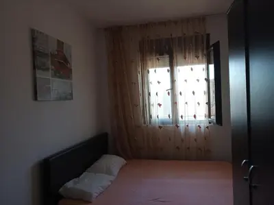 a small bedroom with a bed and a window at Faith Apartman in Budva