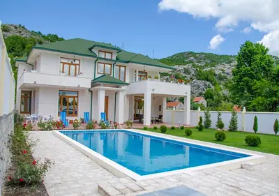 a large house with a swimming pool in front of it at Villa Ramonte in Cetinje