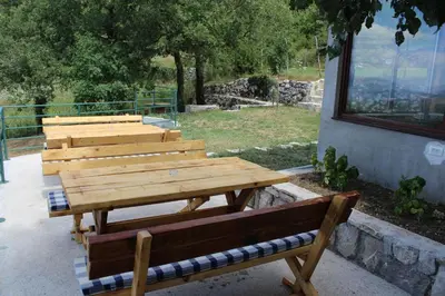 a group of wooden benches sitting next to a building at Forest Apartments in Kotor