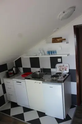 a kitchen with a black and white checkered floor at Forest Apartments in Kotor