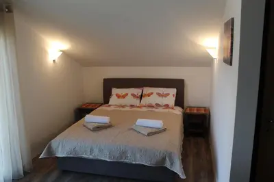 a bedroom with a bed with two towels on it at Forest Apartments in Kotor