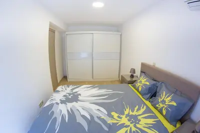 a bedroom with a bed with blue and yellow sheets at Central Budva apartment in Budva