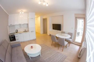 a kitchen and living room with a table and chairs at Central Budva apartment in Budva