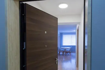 a wooden door leading into a dining room with a table at Central Budva apartment in Budva