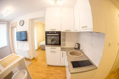 a kitchen with white cabinets and a sink at Central Budva apartment C15 in Budva