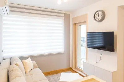 a living room with a couch and a tv at Central Budva apartment C15 in Budva