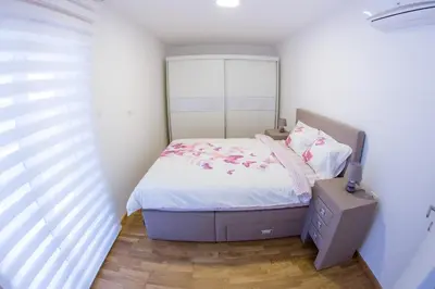 a small bedroom with a bed and a window at Central Budva apartment C15 in Budva