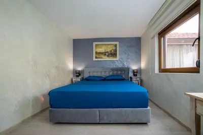 a bedroom with a bed with blue sheets and a window at Villa Sun Castle in Kotor