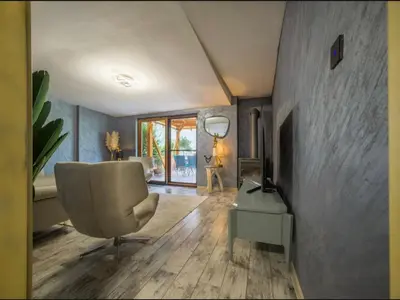 a living room with a chair and a television at Villa Sun Castle in Kotor